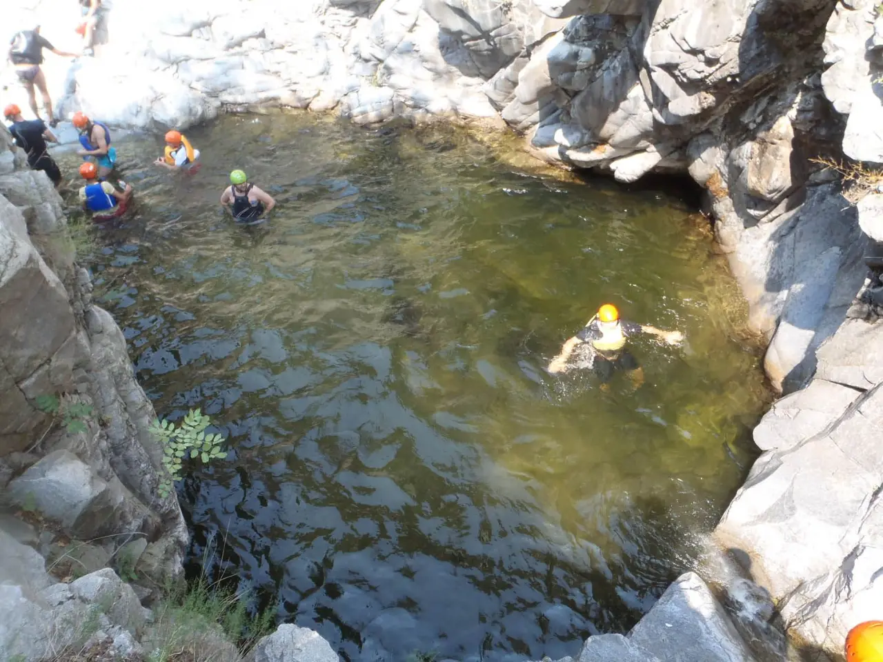 Canyoners swimming across a wide pool in the gorge