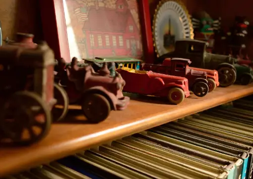Vintage toy cars on a wooden shelf in the workshop