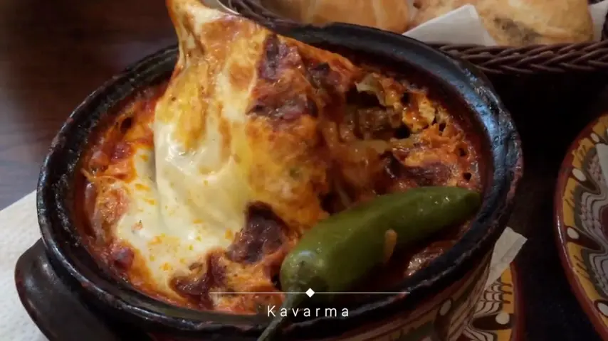 Kavarma bubbling in a clay pot with a green chilli
