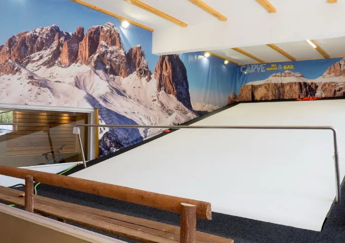 The CARVE indoor ski slope with a mountain mural behind it